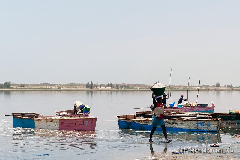 20090529_132426 D3 P1 P1 S1.jpg - It takes about 3 hours to fill a canoe with salt.  It takes about 50 trips to unload the canoe and this takes a full day.  The women is paid in salt.   Each worker has their own 'salt pile' on the beach and then they sell it.  Women make about $2 a day for their work.  The male canoe worker  generally earns more money, especially if he brings the salt to the shore himself in the canoe. It is noted that the minimal agricultural wage in Senegal is $3 per day.  In 2007 the GNP per person was $870  In other words, these woman work very hard, make less than minimal wage and make much less than their male counterparts